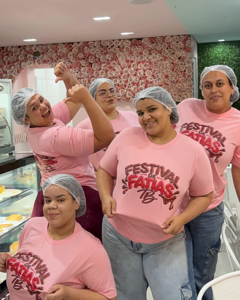As confeiteiras de touca e camiseta rosa do Festival de Fatias, comemorando na loja