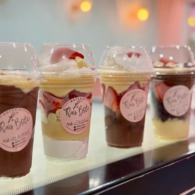 Copos de doce enfileirados na vitrine da loja